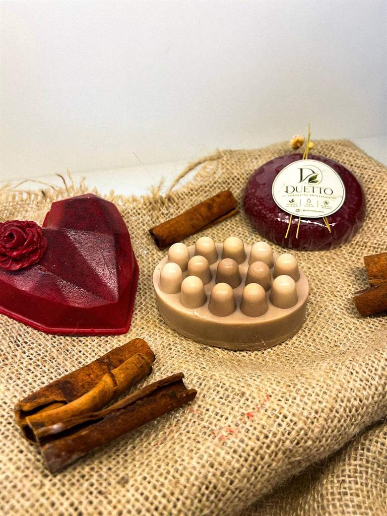 Sabonete massageador bege com coração vinho, canela em pau e sabonete redondo vinho